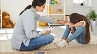 Une femme réconforte une enfant qui pleure